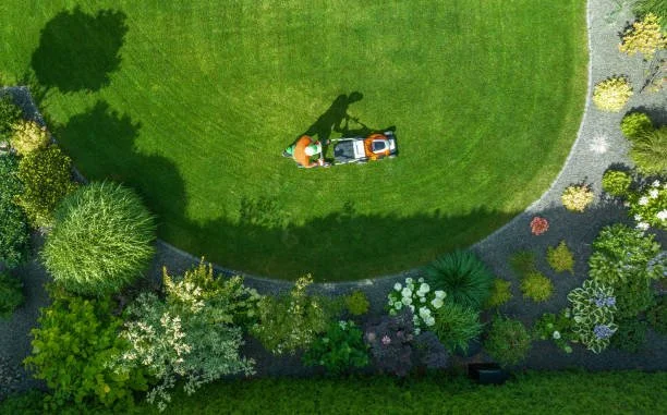 Experienced lawn care professional using commercial mower equipment on a well-maintained yard