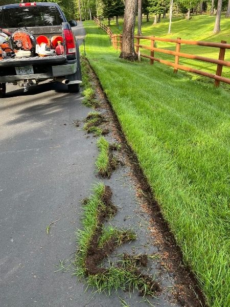 Skilled lawn technician inspecting turf and using precision equipment for a clean finish