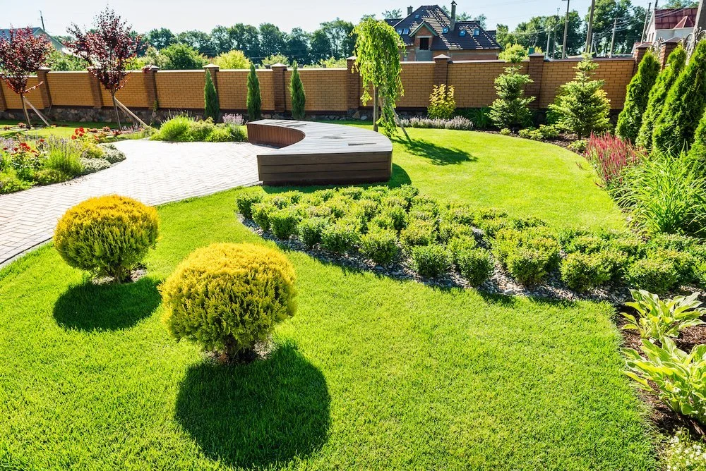 Landscaping crew trimming and shaping a residential yard in Columbia Falls, MT
